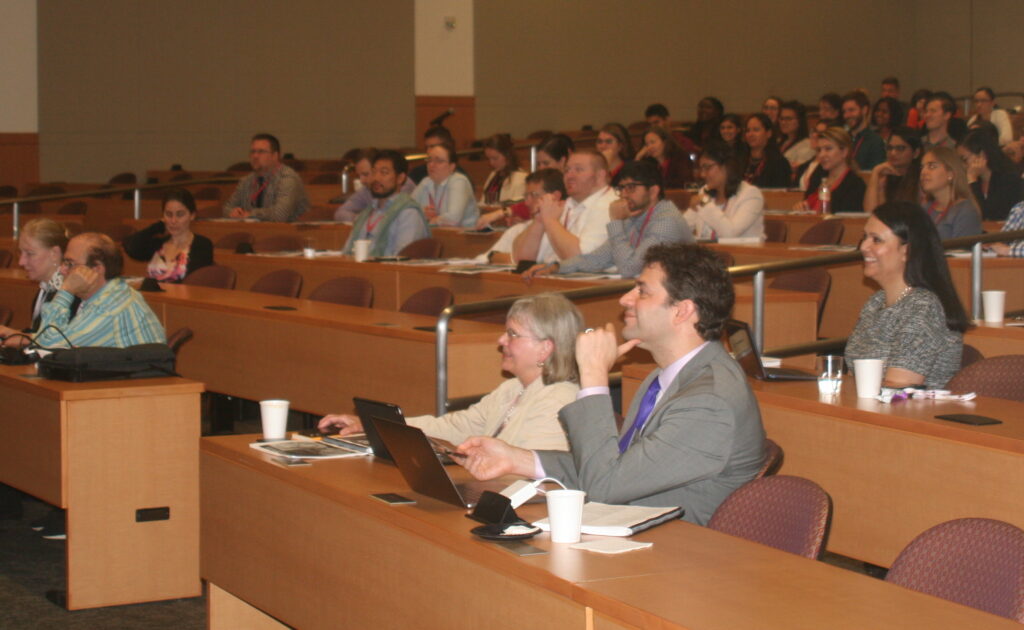 Residents and faculty including Drs. Loder, Silberstein, Digre, Robbins, and Ailani listen to a presentation.